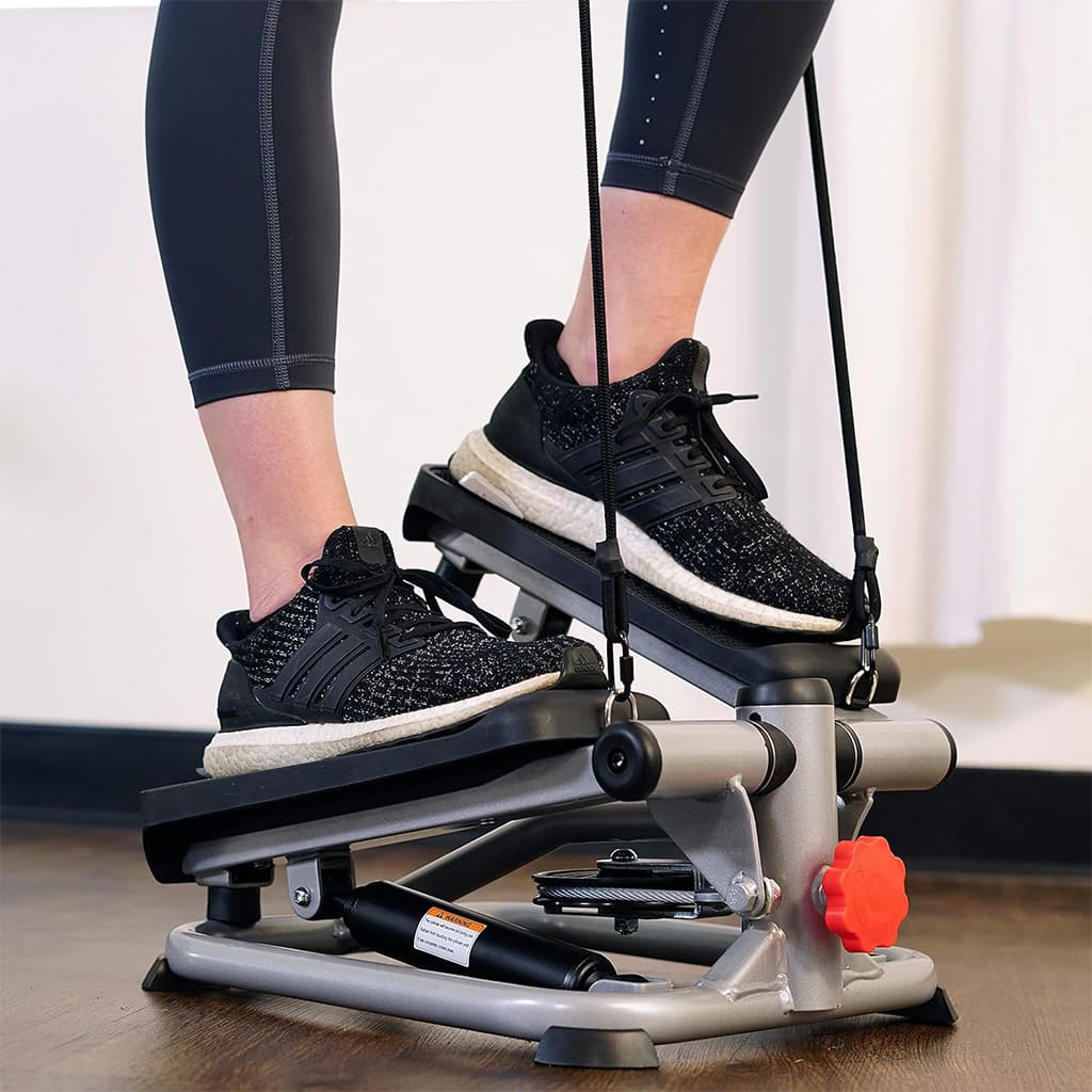 User exercising on AlephNeta StepTone, a compact stair trainer with resistance bands for full body workouts.