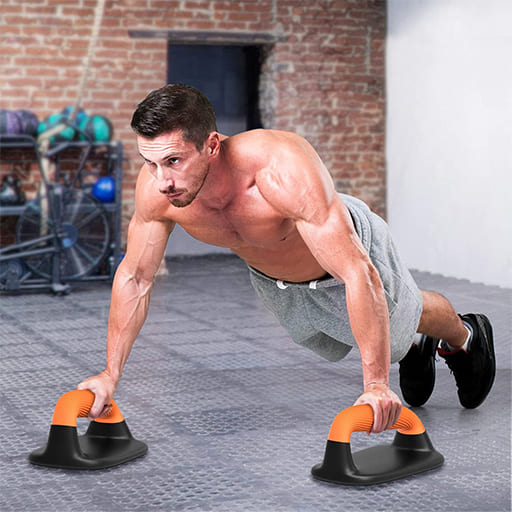 AlephNeta GripForm Handles used for push-ups by a fit man in a gym setting, showcasing ergonomic design and stability.